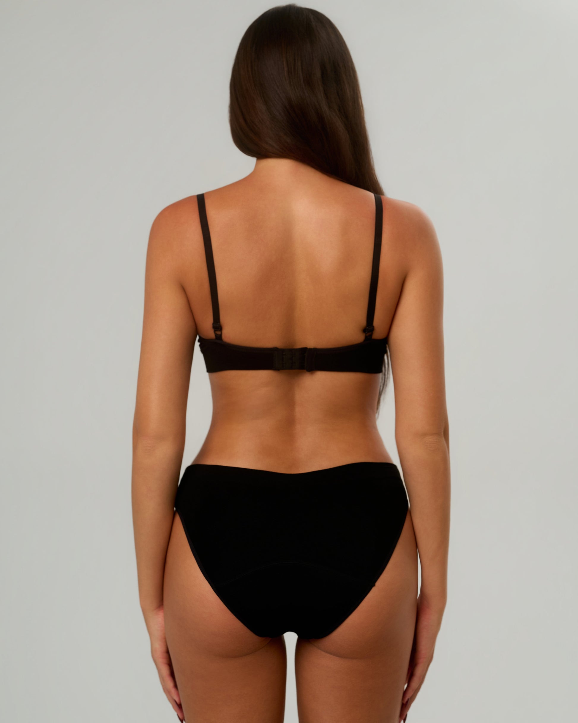Model wearing Rudie black Leakproof Period Brief, full-body rear view — seamless period underwear