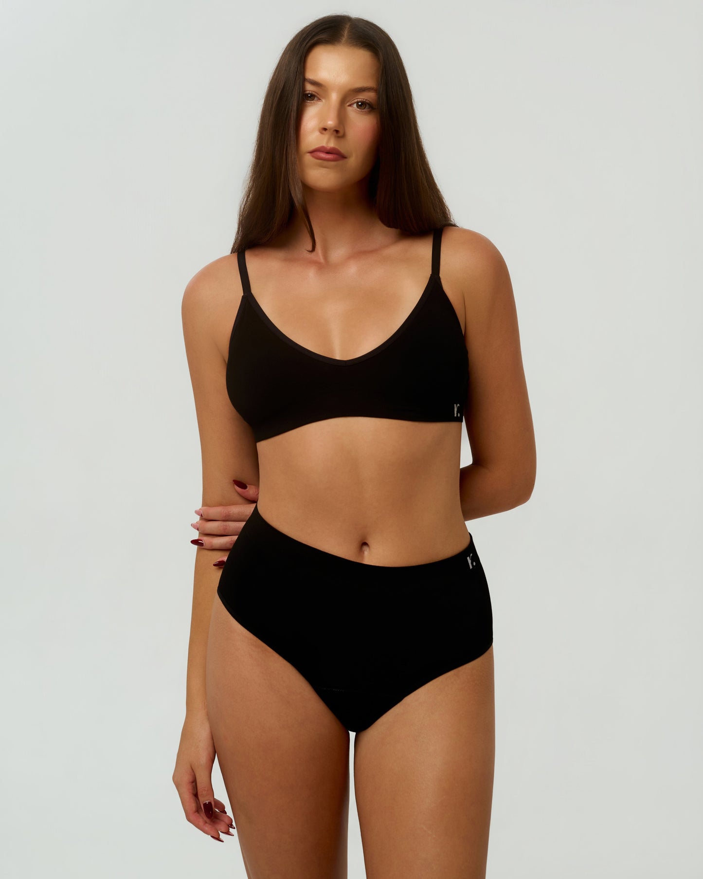 Model wearing Rudie Leakproof High-Waist Brief in black — full body, hands behind back